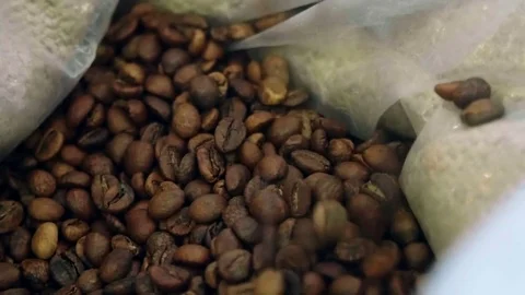 Сoffee beans fall into the pocket close-up Stock Footage 73522237