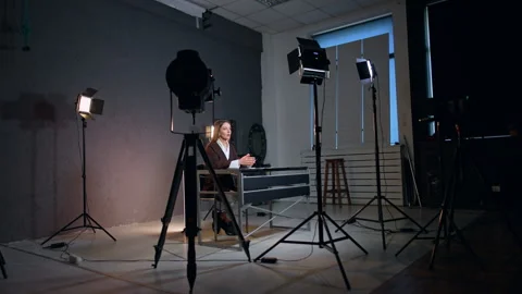 Soffits surround the lady sitting at desk in photo studio. Vídeo Stock 312014829
