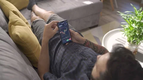 Sofia, Bulgaria-07 08 2021: Young man checking stocks graphics on phone Stock Footage 159340193