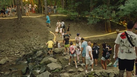 SOFIA, BULGARIA - AUGUST 29, 2026: People crossing stream on rocks and walking Stock-Footage 345900726