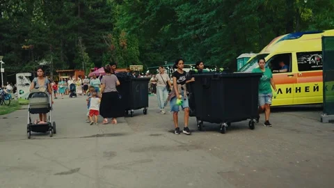 SOFIA, BULGARIA - AUGUST 29, 2026: Volunteers moving large trash dumpsters near 動画素材 345901158