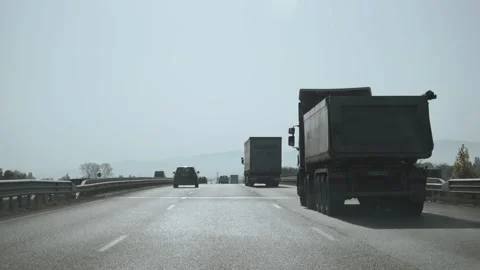 Sofia, Bulgaria - Mar 12, 2025: Trucks and cars traveling on a highway under  Stock Footage 317624706