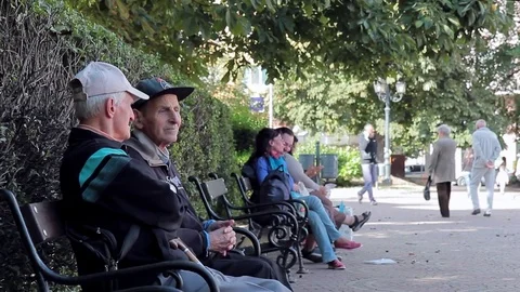 SOFIA, BULGARIA - SEPTEMBER 2016: Two old men talk sitting on bench in park Stock Footage 72828878