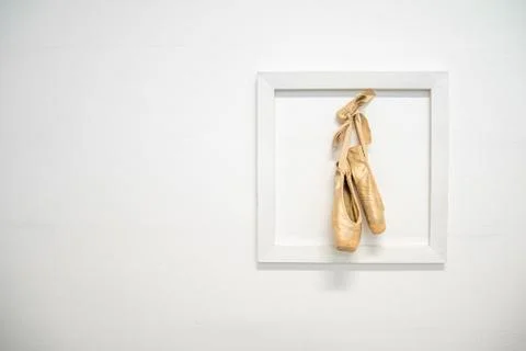Sofia - March 3, 2020: old ballerina shoes hung in a frame on a white wall, as a Stock-Fotos