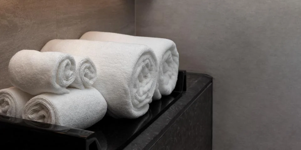 Soft and clean rolled bath towels in spa or bathroom of hotel or resort Stock-Fotos
