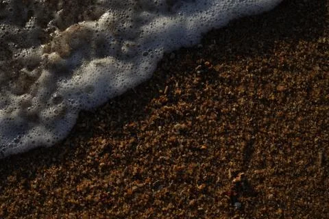 Soft and form ocean wave on clean sandy beach. Stock Photos