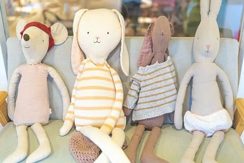 Soft assorted cute plush art toys sitting on the sofa Stock Photos