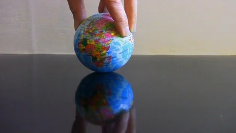 Soft ball with drawn globe turning on a reflective surface Stock-Footage 109271051