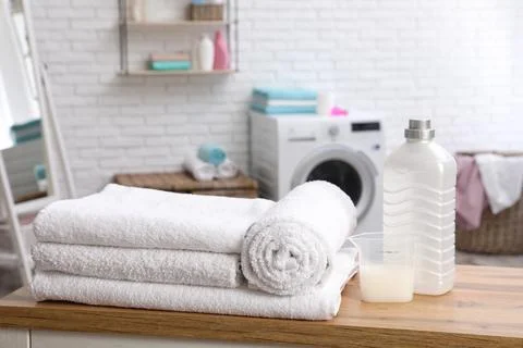 Soft bath towels and detergent on table against blurred background Stock Photos