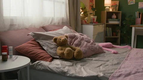 Soft Bear and Pillows on Cozy Bed next to Bedside Table Featuring Pill Bottles Stock Footage 335468435