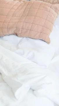 Soft bedding with white sheets and textured pink pillow on bed Foto stock