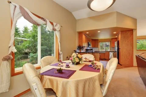 Soft beige dining room interior and nicely decorated table with some flowers  Stock Photos