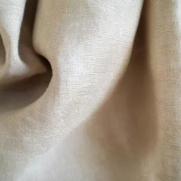 Soft beige fabric with subtle texture and natural folds for minimalist Stock Photos