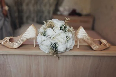 Soft beige heels flank a delicate white bouquet Foto stock
