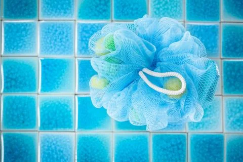 Soft blue bath puff or sponge  on blue tile  background Stock Photos