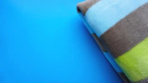Soft blue blanket on blue background. Autumn comfort, space for text, top view Stock Photos