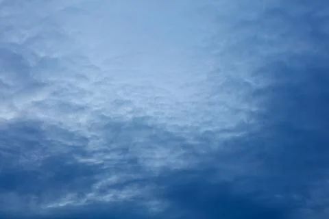 Soft blue clouds drift across serene sky Stock Photos