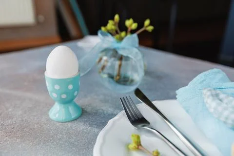 Soft Blue Easter Table with Egg and Floral Vase Foto stock