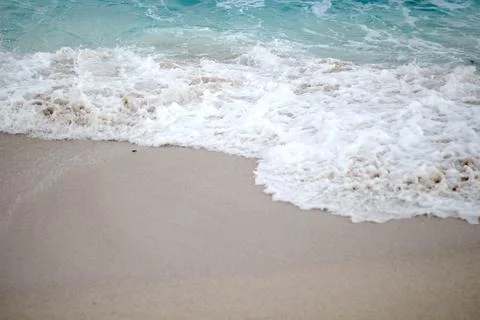 Soft blue ocean wave on a clean sandy beach Stock Photos