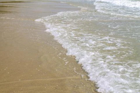 Soft blue ocean wave on sandy beach. Background. Stock Photos