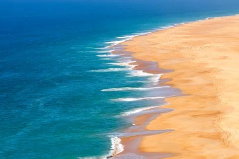 Soft blue ocean wave on sandy beach. Background Stock Photos
