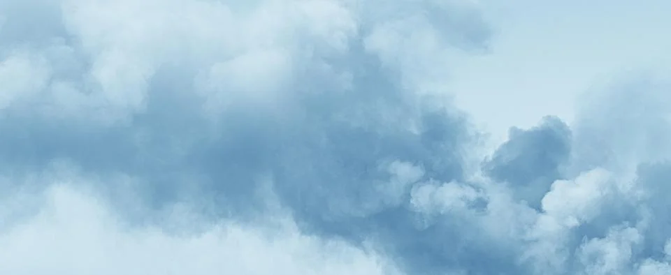 Soft blue sky with light fluffy clouds Stock Photos