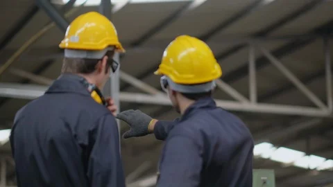 Soft blur scene of the back of two technician men stand and look to machine Stock-Footage 127815421