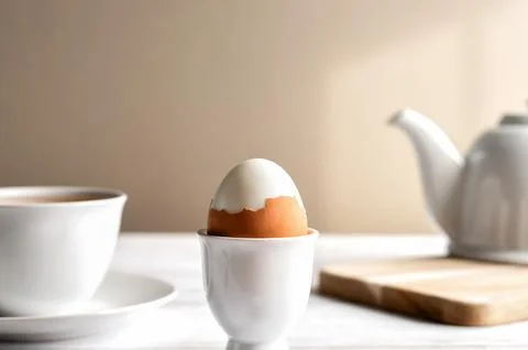 Soft boiled egg for breakfast with tea set with copy space. Stock Photos