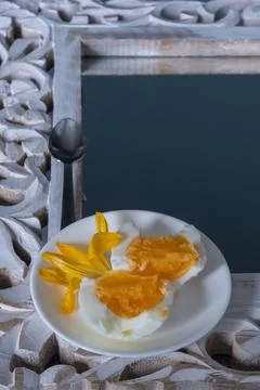A soft-boiled egg, broken in half, beautifully served with a yellow crocus .. Stock Photos