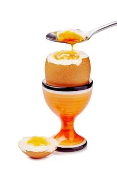 Soft-boiled egg in cup with spoon isolated on white Stock Photos
