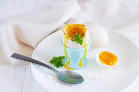 Soft boiled egg in egg cup with herbs and spices for breakfast Stock Photos