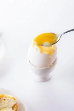 Soft boiled egg in egg cup on white background, plate and cup. Close up. Sele Stock Photos