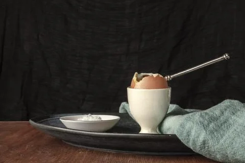 A soft-boiled egg with salt, a side view photo on a dark background with a place Stock-Fotos