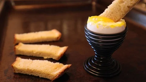 Soft Boiled Egg with Sliced Toast Dipped in Egg - Traditional British Breakfast Stock Footage 124878694