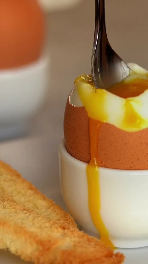 Soft-boiled egg with toast bread. Spoon scoops up chicken yolk. Breakfast. Food Stock Footage 306654498