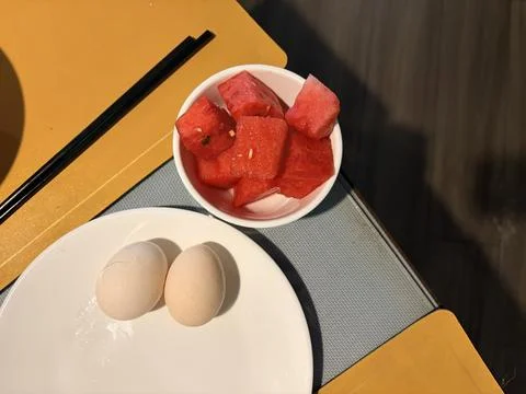 Soft-Boiled Eggs and Watermelon Cubes on a Yellow Table Stock Photos