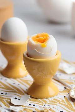 Soft-boiled eggs in a yellow eggcups Foto stock