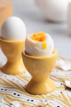 Soft-boiled eggs in a yellow eggcups Stock Photos