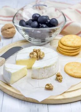 Soft brie cheese with crackers nuts and olives Foto stock