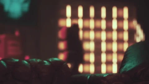 Soft brown couch in a room with colored lights showing glowing patterns Stock Footage 344995867