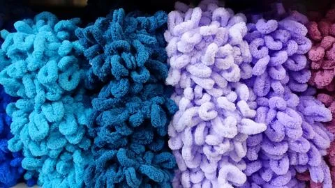 Soft bulk colored yarn on shelf in the store. Stock Photos