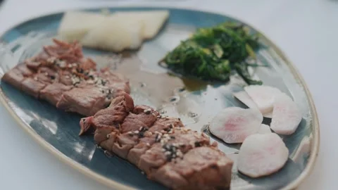 Soft camera move over red tuna steak, seaweed salad, restaurant plate Stock Footage 321193341