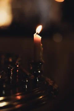 Soft candle flame glows warmly against dark background Foto stock