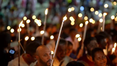 Soft candlelight reflects on faces filled with faith Video stock 318094059