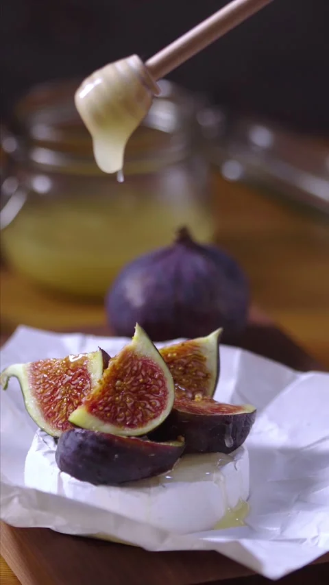 Soft cheese appetizer topped with sliced figs, honey on wooden background Stock Footage 218232381