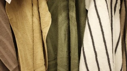 Soft clean folded towels hanging on a hook. Colorful towels in a  laundry room Stock Footage 320971930