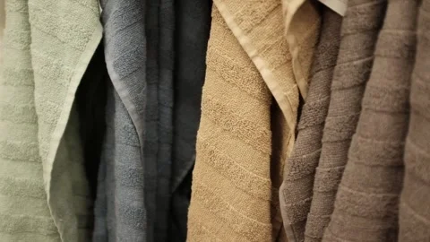 Soft clean folded towels hanging on a hook. Colorful towels in a  laundry room Stock Footage 320971999