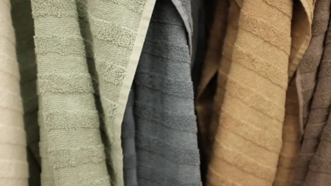Soft clean folded towels hanging on a hook. Colorful towels in a  laundry room Stock Footage 320972242