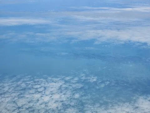 Soft cloud layer above turquoise terrain Stock Photos