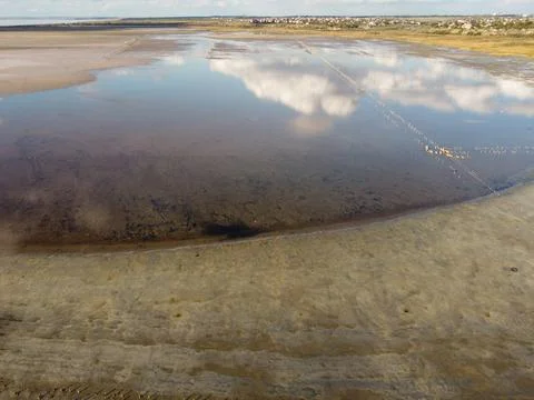 Soft clouds are mirrored in the still surface of the lake Stock-Fotos
